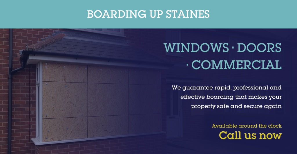 Plywood board fixed over a broken window on a house in Staines